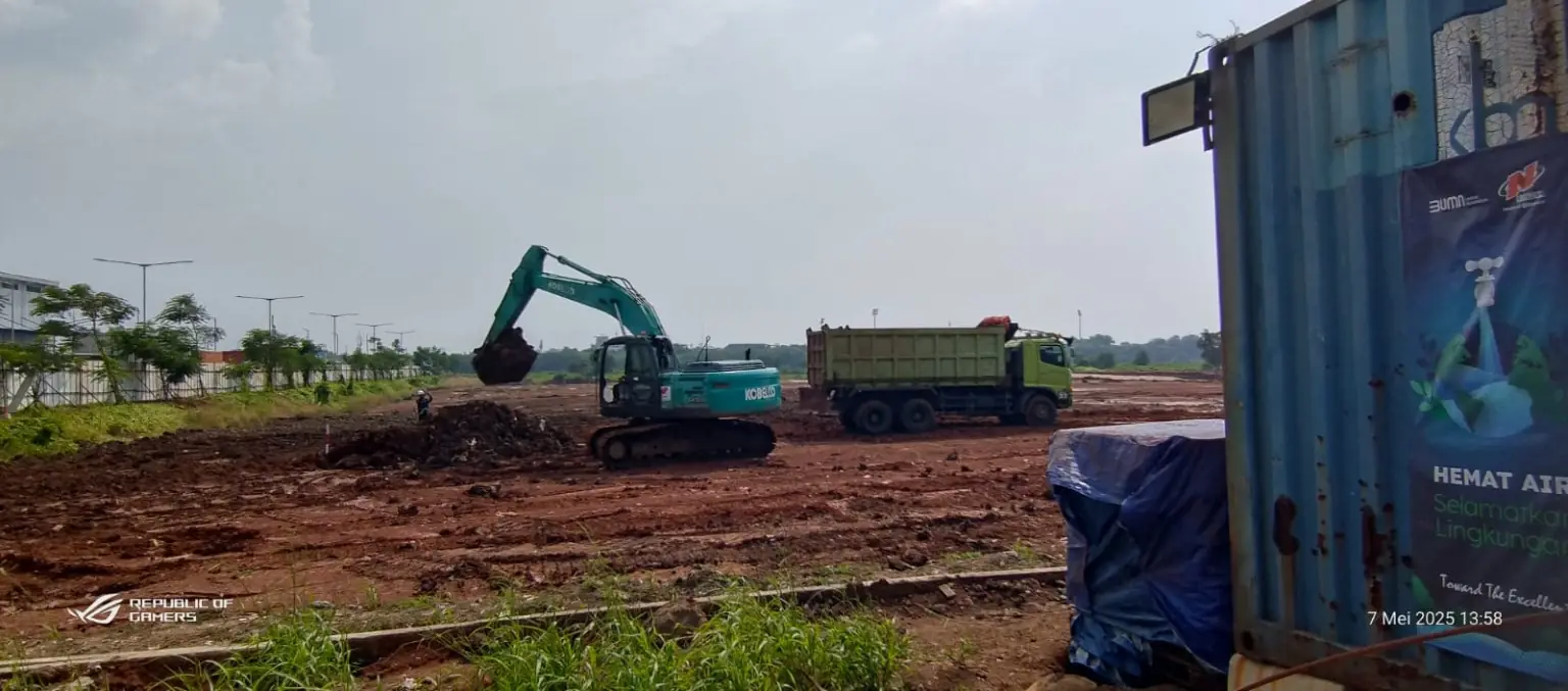 Excavator dan dump truck pada pekerjaan pembersihan lahan