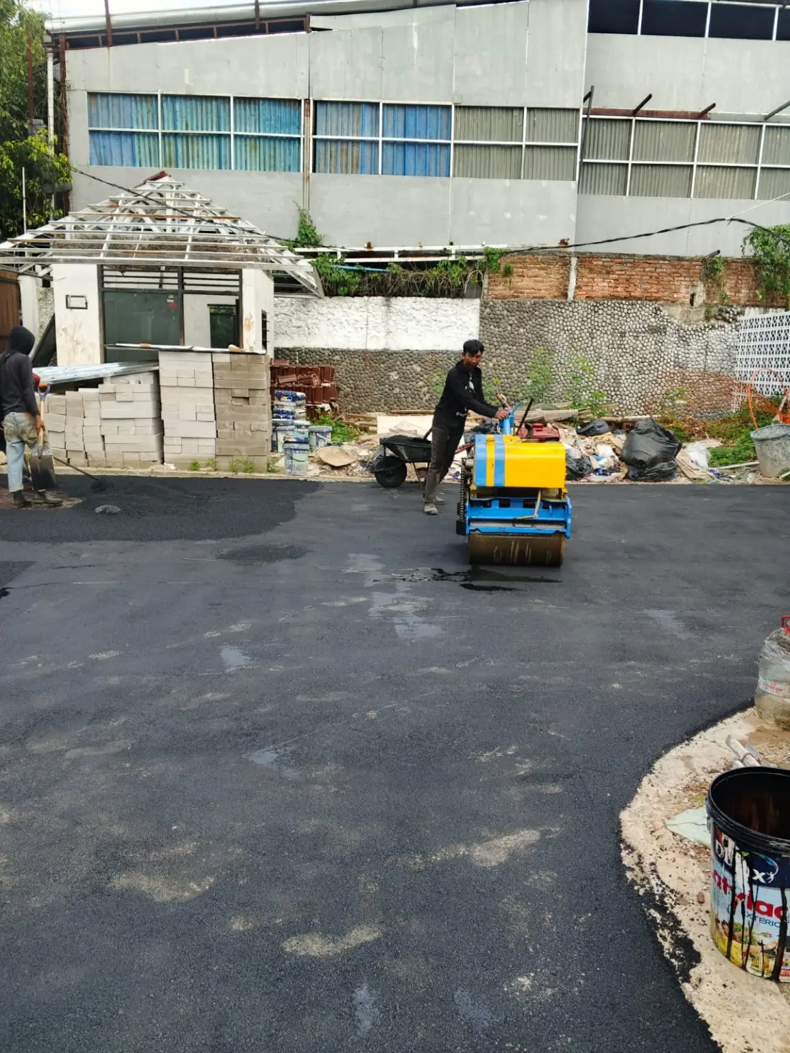 Proses pemadatan pengaspalan menggunakan baby roller